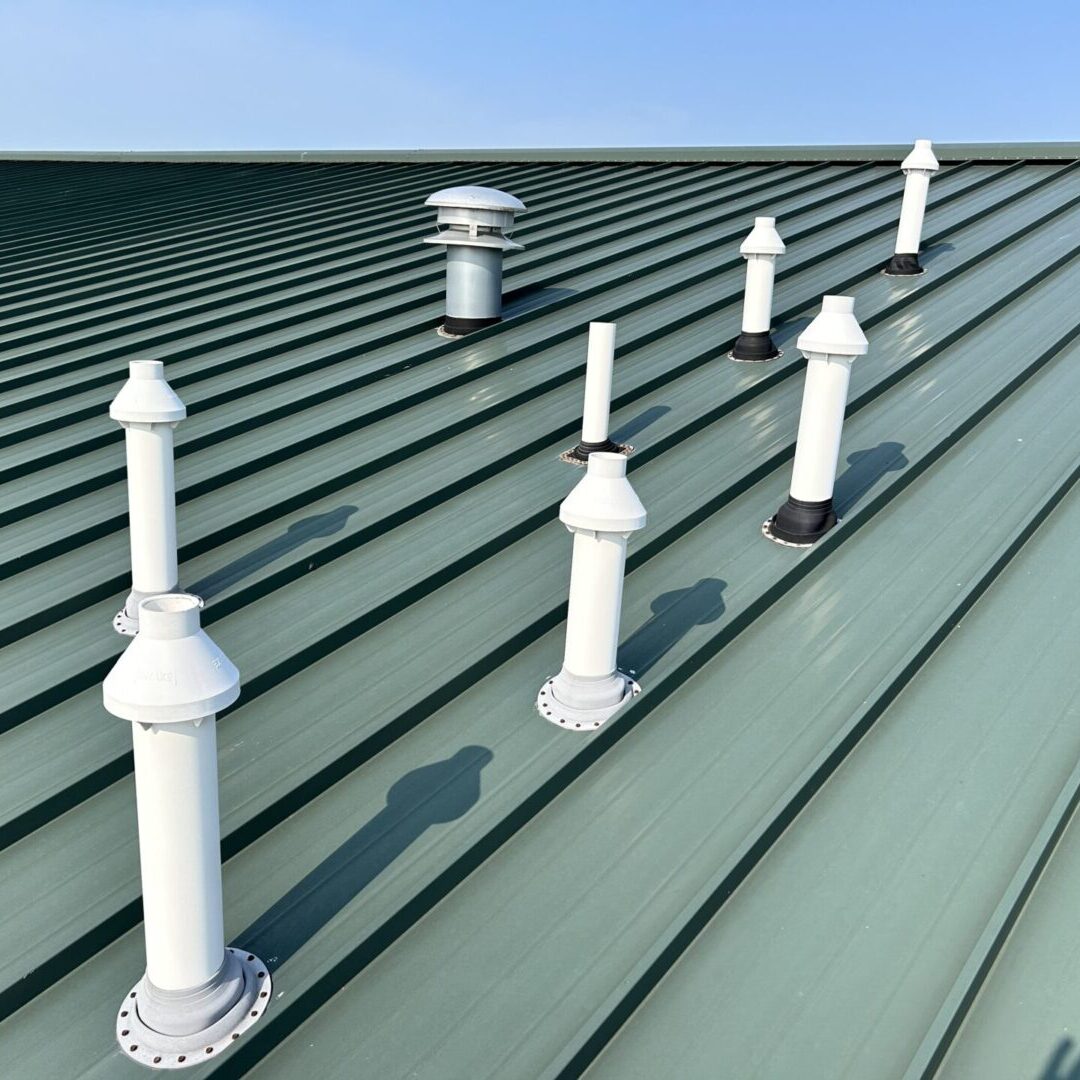 A close up of the roof of a building with several different types of vents.